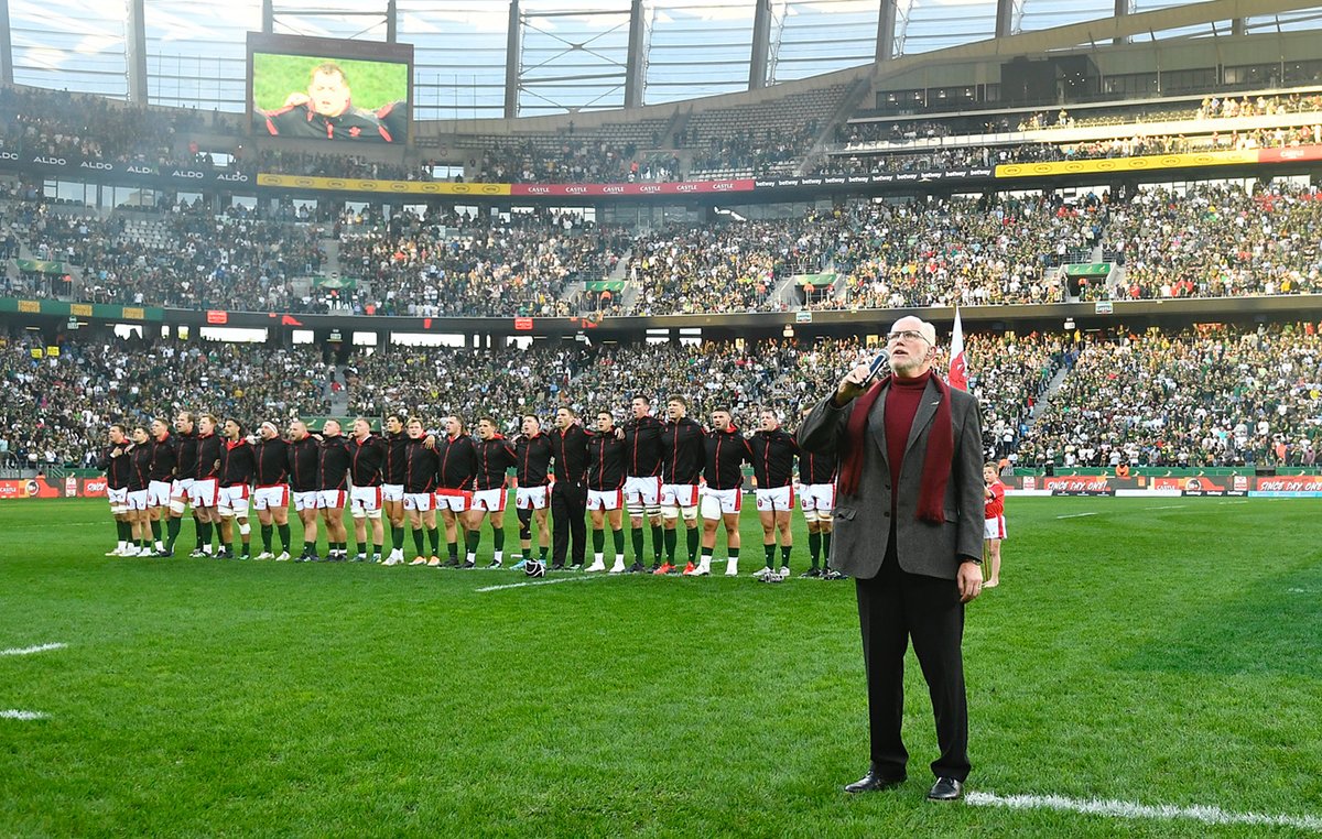 Singing the national anthem on the pitch before a packed rugby stadium