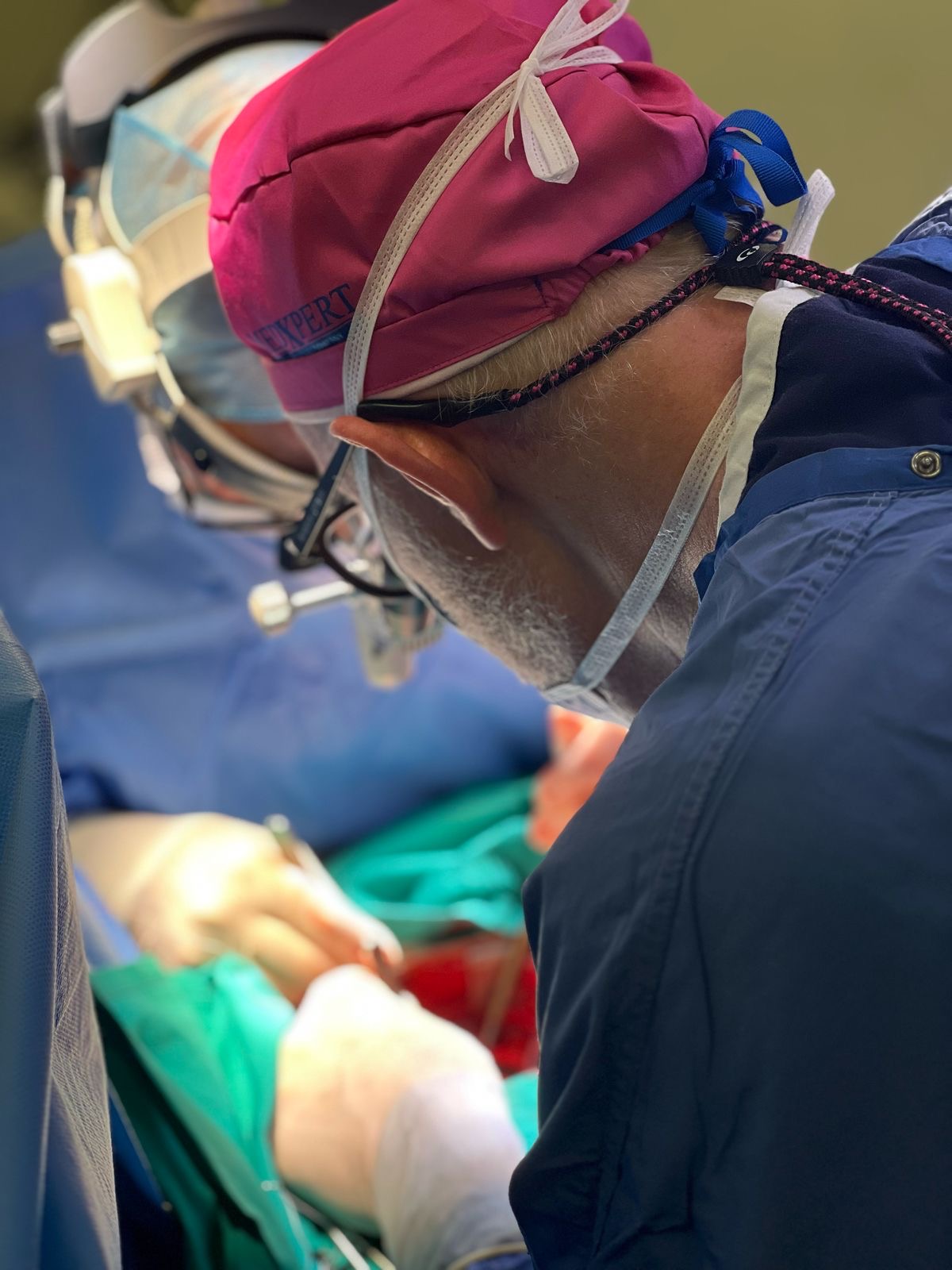 Close-up view from behind a surgeon focused intently during an operation